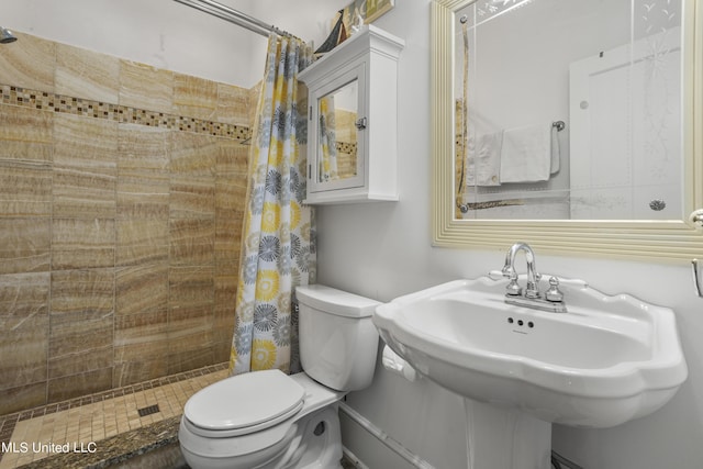 full bath featuring a sink, toilet, and tiled shower