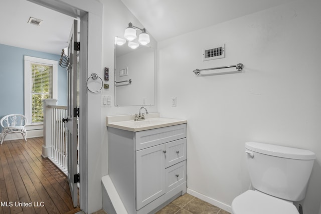 bathroom featuring vanity, baseboards, toilet, and visible vents