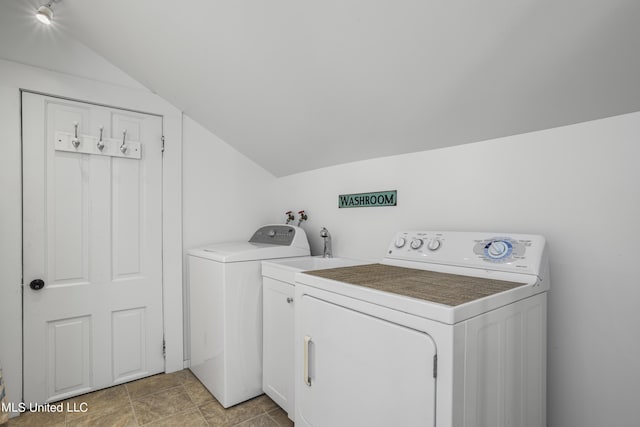 clothes washing area with separate washer and dryer and cabinet space