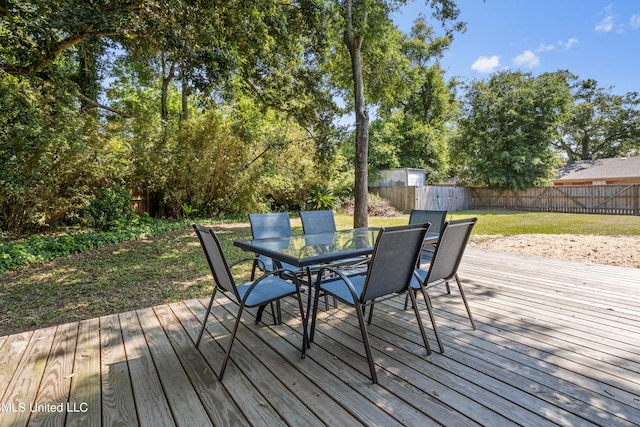 deck featuring a storage unit and a lawn