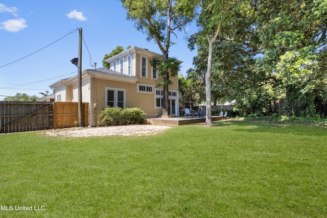 back of house featuring a yard and a deck