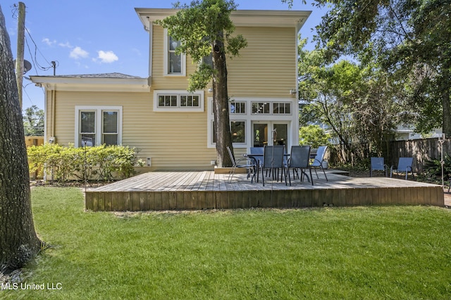 back of house featuring fence, a yard, and a deck