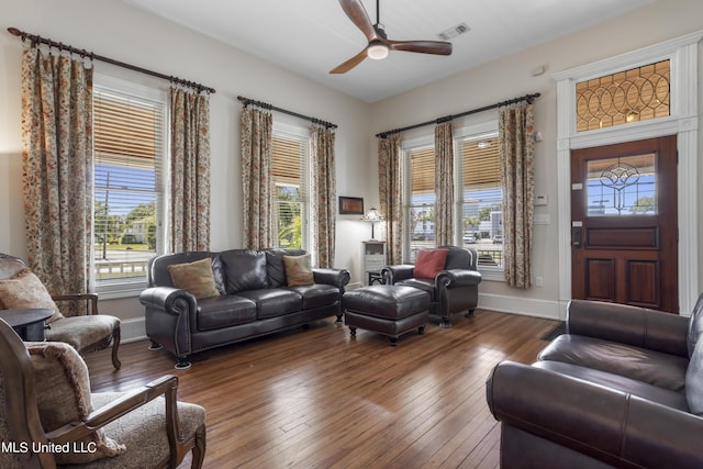 living room with wood-type flooring, ceiling fan, visible vents, and a healthy amount of sunlight