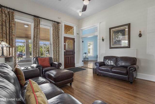 living room with baseboards, ceiling fan, and wood finished floors