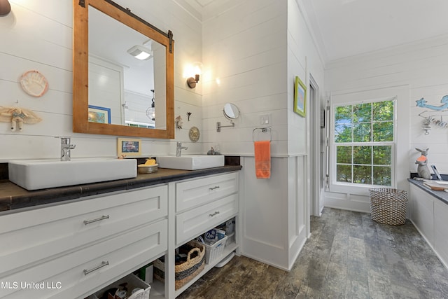 bathroom featuring vanity, crown molding, hardwood / wood-style flooring, and wood walls