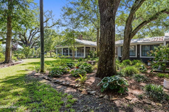 exterior space featuring a front lawn and a sunroom