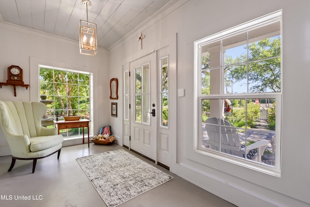 foyer with ornamental molding and concrete flooring