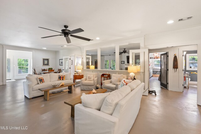 living room featuring concrete flooring, plenty of natural light, and ceiling fan