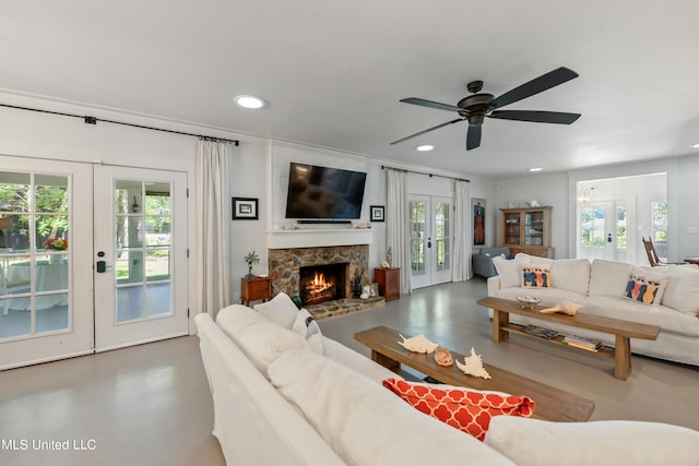 living room with french doors, a fireplace, and ceiling fan