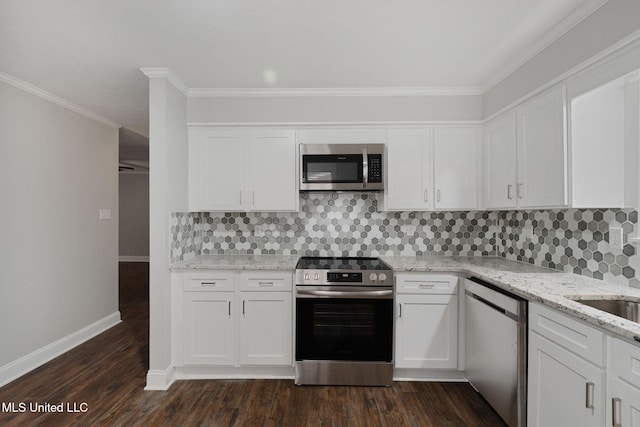 kitchen with tasteful backsplash, appliances with stainless steel finishes, white cabinets, dark wood-type flooring, and ornamental molding