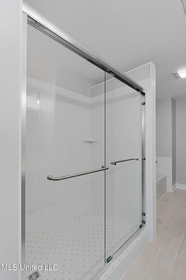 bathroom featuring tile patterned floors and a shower with shower door