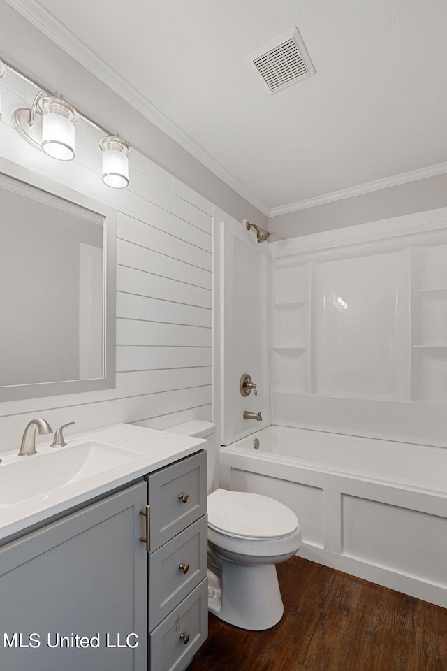 full bathroom featuring hardwood / wood-style floors, shower / tub combination, toilet, vanity, and crown molding