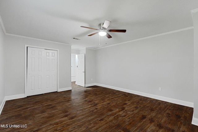 unfurnished bedroom featuring dark wood-type flooring, ceiling fan, crown molding, and a closet