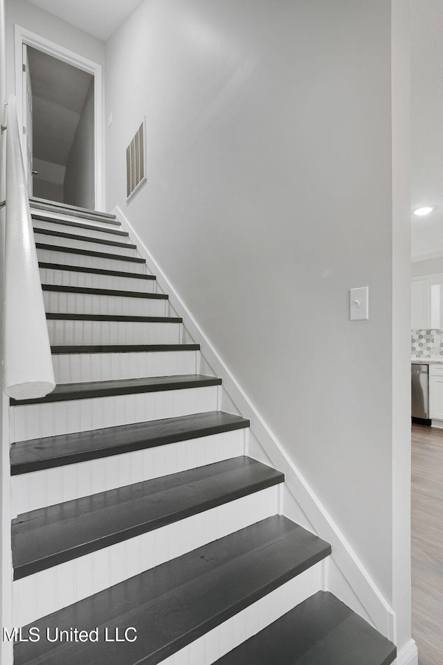 staircase with wood-type flooring