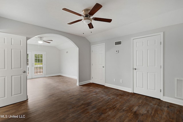 empty room featuring lofted ceiling, dark hardwood / wood-style floors, and ceiling fan