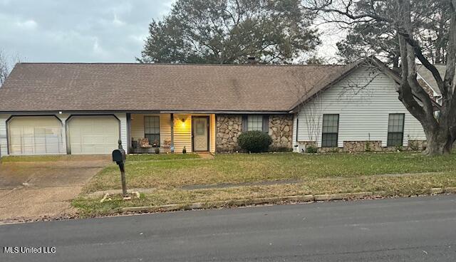 ranch-style house featuring a garage and a front yard