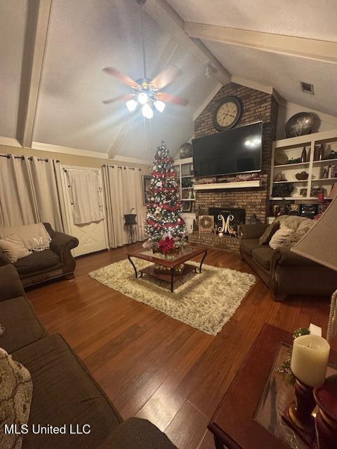 living room with a brick fireplace, hardwood / wood-style flooring, lofted ceiling with beams, and ceiling fan