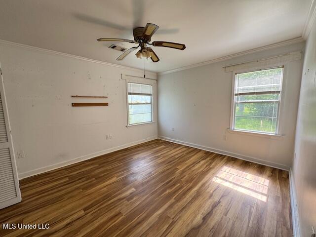 165 Canal St, Gulfport, MS 39507 - empty room featuring crown molding, wood finished floors, baseboards, and a ceiling fan