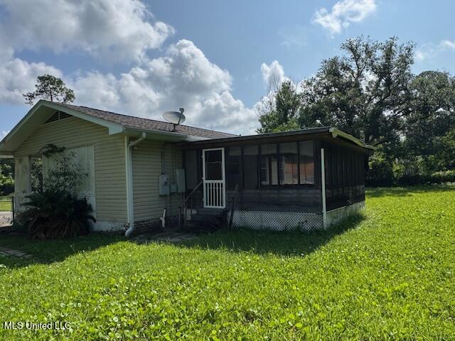 165 Canal St, Gulfport, MS 39507 - view of front of house featuring a front lawn, a sunroom, and entry steps