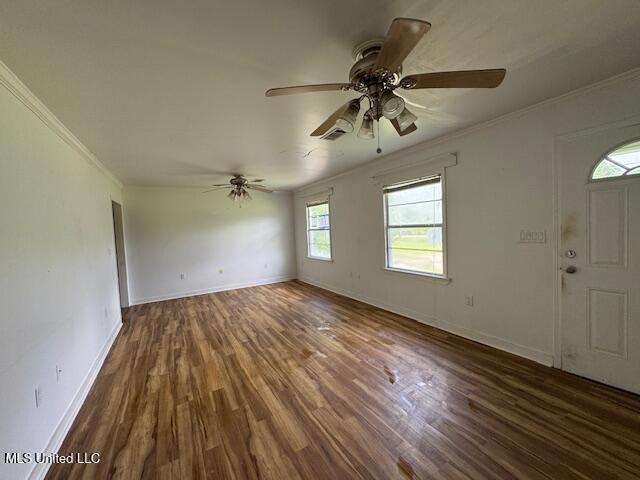165 Canal St, Gulfport, MS 39507 - unfurnished living room with crown molding, wood finished floors, ceiling fan, and baseboards