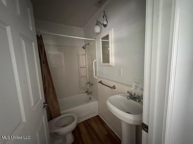 165 Canal St, Gulfport, MS 39507 - full bathroom featuring shower / tub combo with curtain, wood finished floors, and toilet