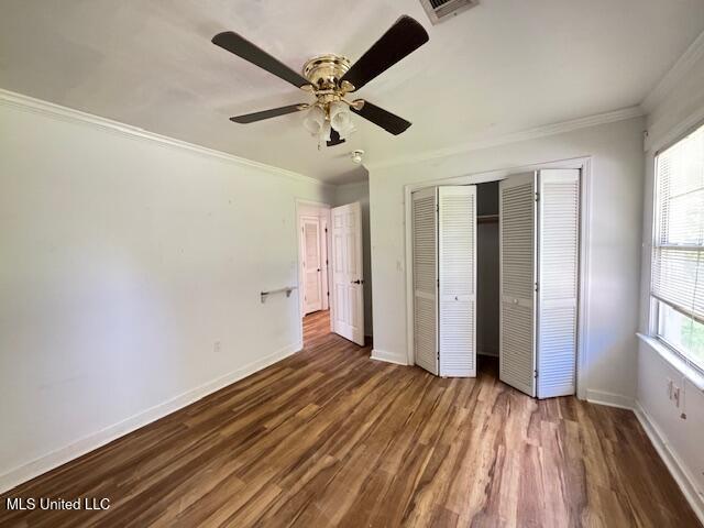 165 Canal St, Gulfport, MS 39507 - unfurnished bedroom with ornamental molding, a closet, wood finished floors, baseboards, and ceiling fan