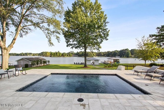 view of swimming pool featuring a patio, a lawn, and a water view