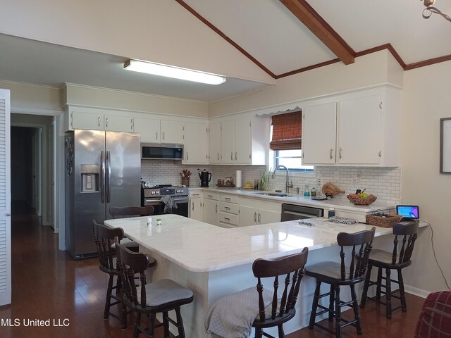 114 S 49th Hwy, Indianola, MS 38751 - kitchen featuring stainless steel appliances, a sink, a peninsula, white cabinets, and ornamental molding