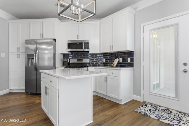 2252 Beach Dr Unit 606, Gulfport, MS 39507 - kitchen featuring stainless steel appliances, dark wood finished floors, backsplash, a center island, and ornamental molding
