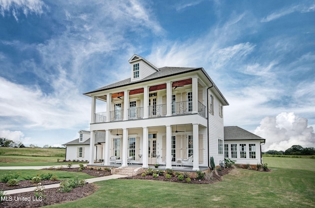 view of front of property with a porch, a balcony, a front yard, and ceiling fan