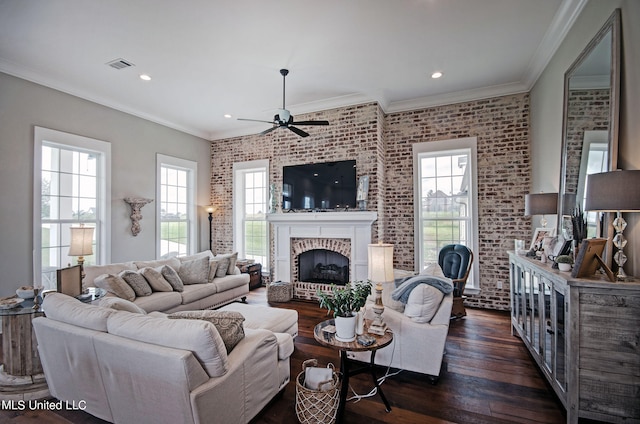 living room featuring dark hardwood / wood-style flooring, a brick fireplace, brick wall, and a wealth of natural light