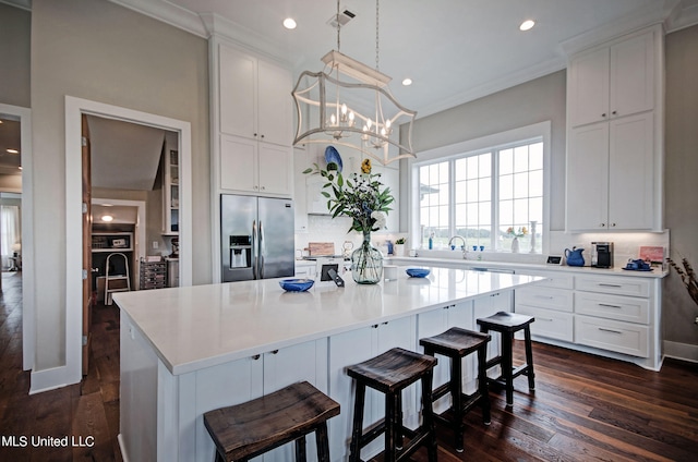 kitchen with dark hardwood / wood-style floors, tasteful backsplash, a center island, and stainless steel fridge with ice dispenser