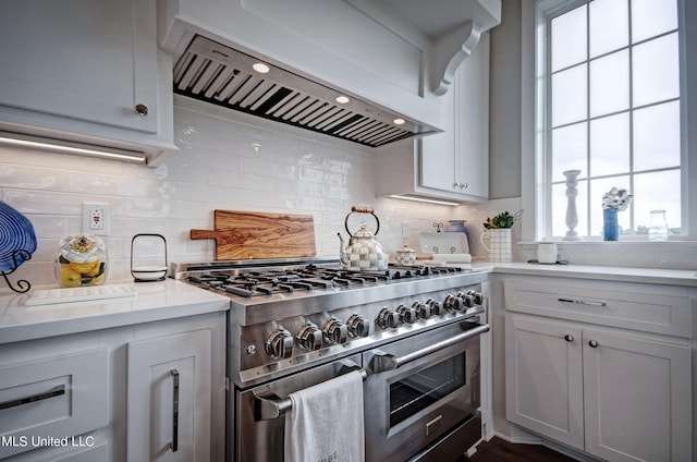 kitchen with decorative backsplash, exhaust hood, and double oven range