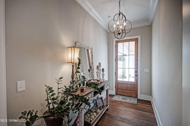 foyer with a notable chandelier, ornamental molding, and dark wood-type flooring