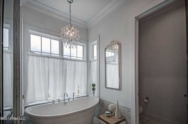 bathroom with crown molding, a notable chandelier, toilet, and a bathing tub