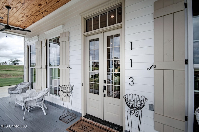 view of exterior entry featuring covered porch and ceiling fan