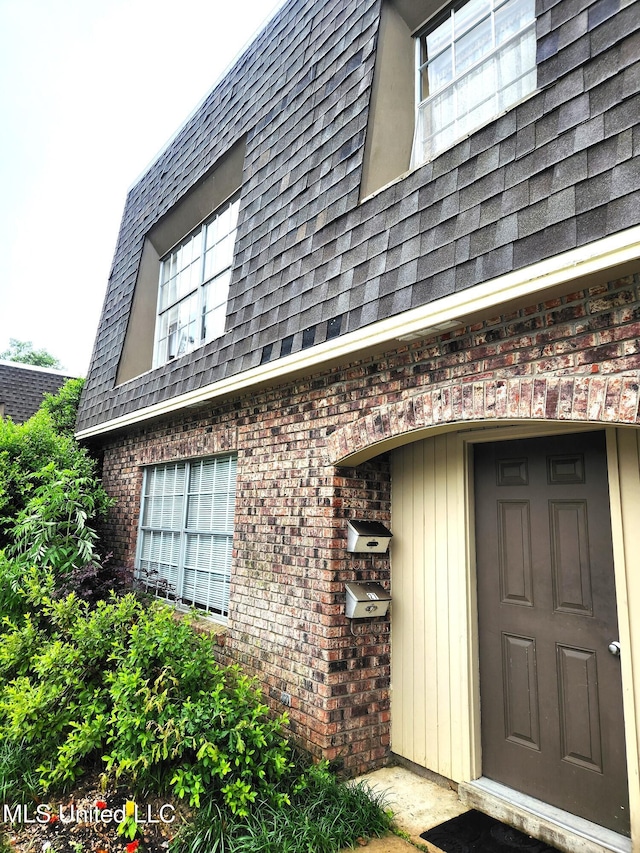 413 Kahler St Unit 27, Gulfport, MS 39507 - property entrance with brick siding, roof with shingles, and mansard roof