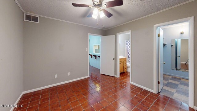 413 Kahler St Unit 27, Gulfport, MS 39507 - unfurnished bedroom featuring a textured ceiling, baseboards, dark tile patterned flooring, ornamental molding, and ensuite bathroom