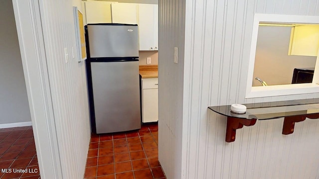 413 Kahler St Unit 27, Gulfport, MS 39507 - kitchen with freestanding refrigerator, dark tile patterned floors, a breakfast bar area, and white cabinets