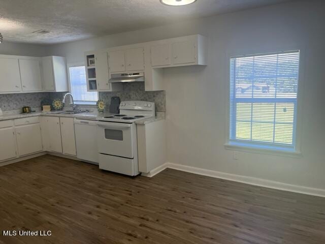 kitchen with white cabinets, tasteful backsplash, dark wood-type flooring, sink, and white appliances