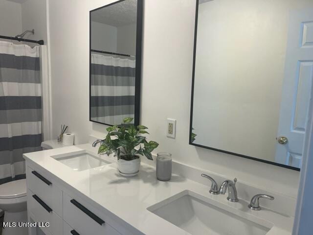 bathroom featuring vanity, a shower with shower curtain, and toilet