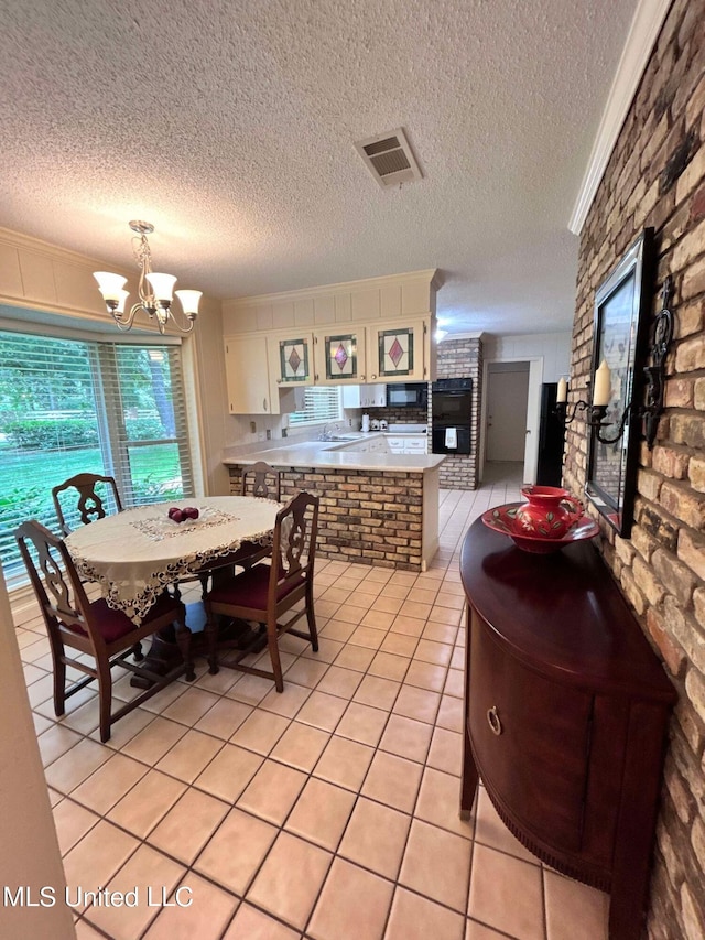 dining room with an inviting chandelier, a textured ceiling, and light tile patterned flooring