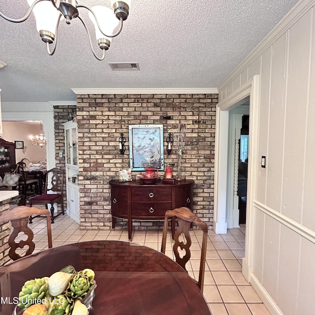 tiled dining space featuring ornamental molding and a textured ceiling