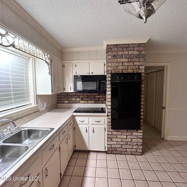 kitchen with white cabinets, light tile patterned floors, a textured ceiling, black appliances, and sink