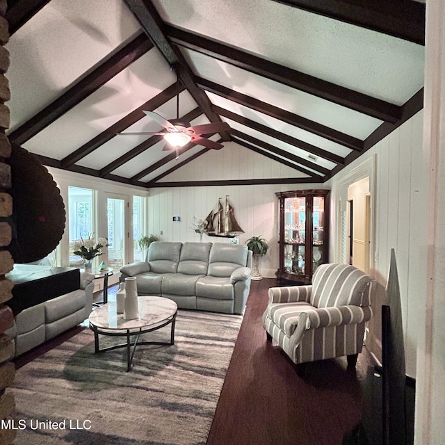 living room with hardwood / wood-style floors, ceiling fan, a textured ceiling, lofted ceiling with beams, and wooden walls