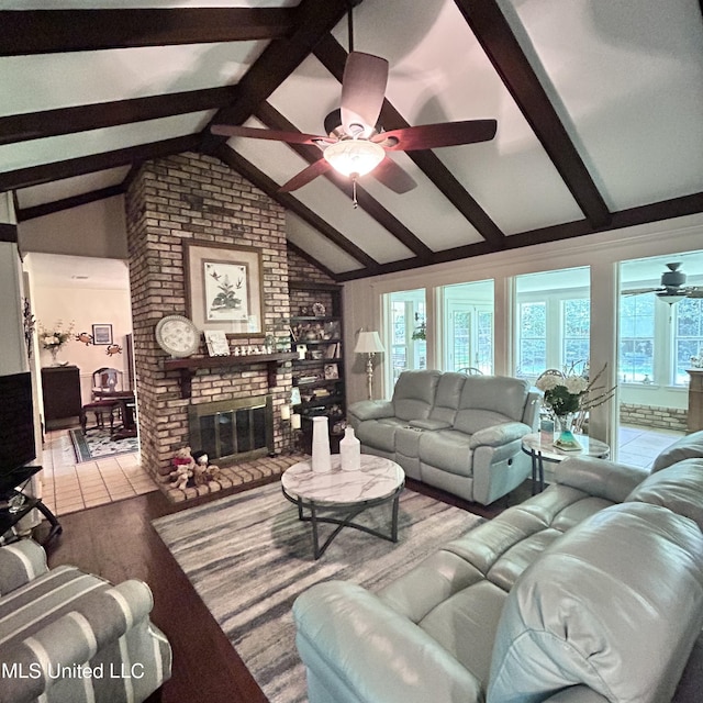 living room with light tile patterned flooring, a healthy amount of sunlight, lofted ceiling with beams, and a fireplace