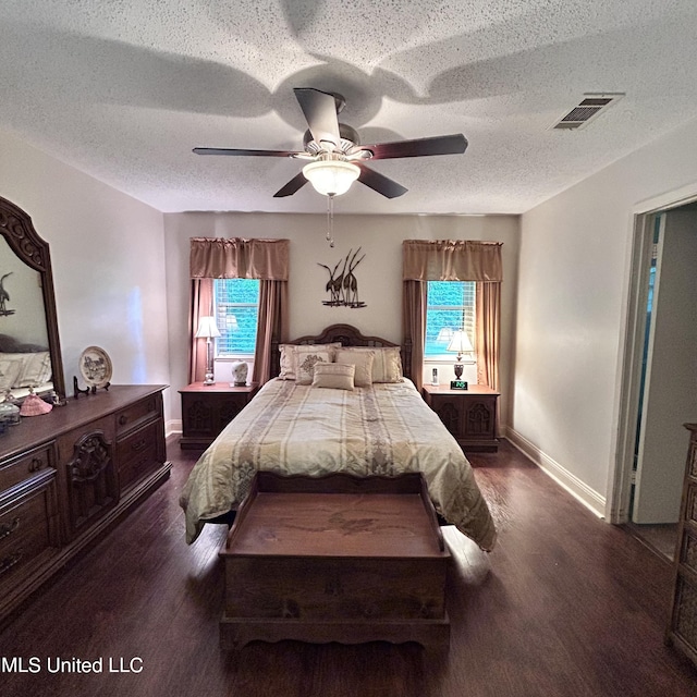 bedroom featuring dark hardwood / wood-style flooring, a textured ceiling, and ceiling fan