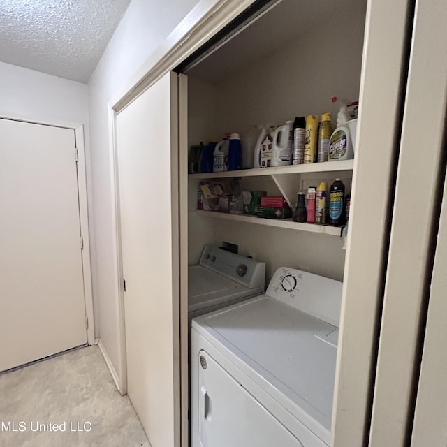 laundry room featuring a textured ceiling and washing machine and clothes dryer