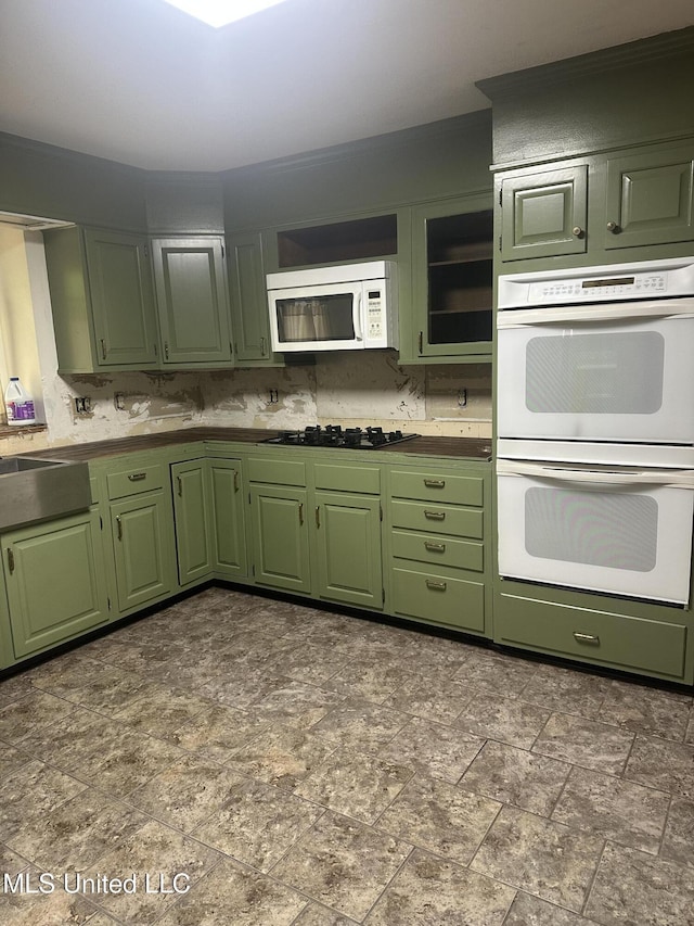 204 Fort Dr, Grenada, MS 38901 - kitchen featuring stone finish flooring, green cabinetry, a sink, and white appliances
