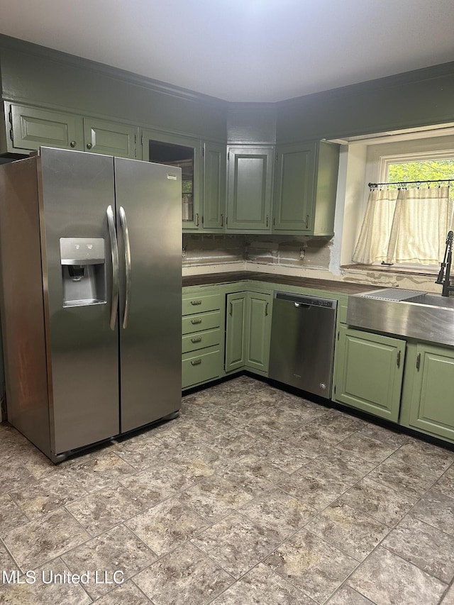 204 Fort Dr, Grenada, MS 38901 - kitchen with green cabinetry, a sink, appliances with stainless steel finishes, and stone finish flooring